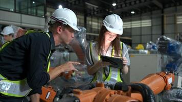 Both of engineers working together in a robotic arm factory, Robotic arm industry and engineering concept. photo