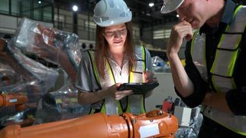 Both of engineers working together in a robotic arm factory, Robotic arm industry and engineering concept. photo