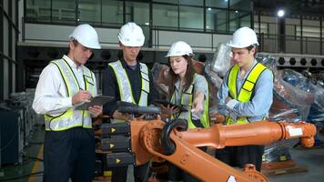 grupo de ingenieros y técnicos trabajando juntos en un robótico brazo fábrica. inspeccionando robot brazo antes de entregando a clientes foto