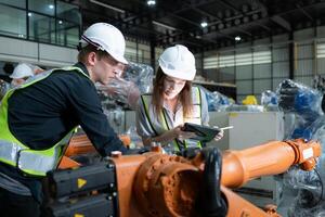 Both of engineers working together in a robotic arm factory, Robotic arm industry and engineering concept. photo