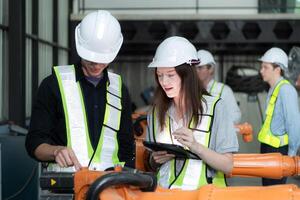 Group of engineers and technicians working together in a robotic arm factory. Inspecting robot arm before delivering to customers photo