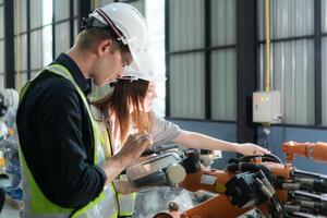 Both of engineers working together in a robotic arm factory, Robotic arm industry and engineering concept. photo