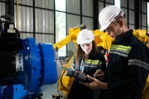 Both of engineers working together in a robotic arm factory, Robotic arm industry and engineering concept. photo