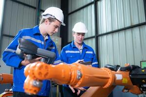 Engineer and technician working with robot arm in factory. Industry and engineering concept. photo