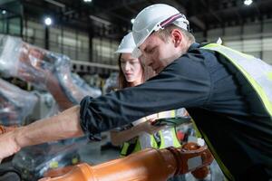 Both of engineers working together in a robotic arm factory, Robotic arm industry and engineering concept. photo