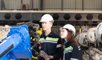 Both of engineers working together in a robotic arm factory, Robotic arm industry and engineering concept. photo