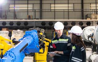 Both of engineers working together in a robotic arm factory, Robotic arm industry and engineering concept. photo