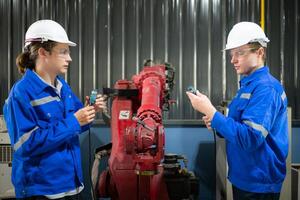 Engineers and technicians working together in a robotic arm factory, Check the power transmission lines of the robotic arm. photo