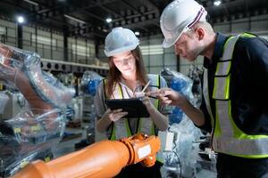 Both of engineers working together in a robotic arm factory, Robotic arm industry and engineering concept. photo