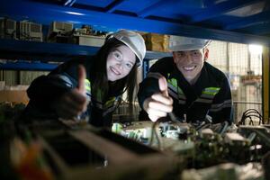 un joven hembra ingeniero y un masculino supervisor trabajo juntos en robótico brazo de repuesto partes depósito, robótico brazo industria y Ingenieria concepto. foto