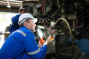 ambos de ingenieros trabajando juntos en un robótico brazo fábrica, robótico brazo industria y Ingenieria concepto. foto