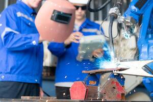 Industrial workers working with robotic arm welding machine in factory, Robotic arm welding industry and engineering concept. photo
