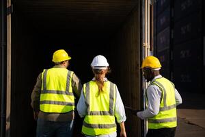 Group of workers in an empty container storage yard, The condition of the old container is being assessed to determine whether it requires maintenance for usage. photo