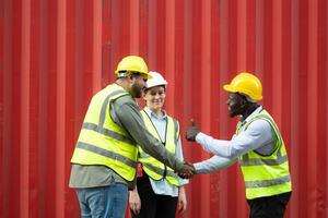 Group of workers in a container storage yard greeting each other during breaks in front of container warehouse, photo