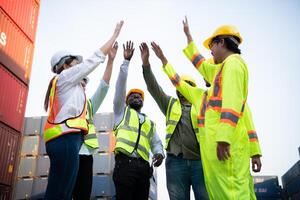 A group of happy team workers stood hand in hand to show their strength and power to start work, In the container storage yard photo