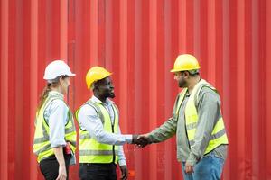 Group of workers in a container storage yard greeting each other during breaks in front of container warehouse, photo