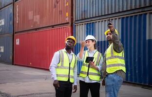 Group of engineers working with laptop in the container yard. This is a freight transportation and distribution warehouse. photo