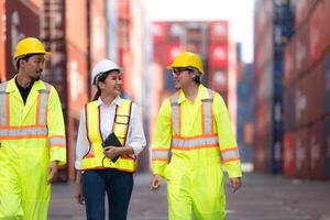 Group of engineers working with laptop in the container yard. This is a freight transportation and distribution warehouse. photo