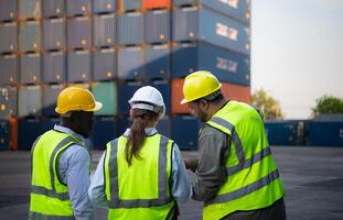 Group of engineers working with laptop in the container yard. This is a freight transportation and distribution warehouse. photo