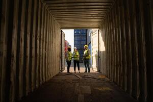 Group of workers in an empty container storage yard, The condition of the old container is being assessed to determine whether it requires maintenance for usage. photo