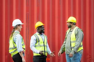 Group of workers in a container storage yard greeting each other during breaks in front of container warehouse, photo