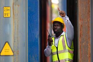 Portrait of male worker holding walkie talkie in front of container photo