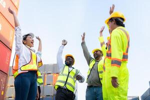 A group of happy team workers stood hand in hand to show their strength and power to start work, In the container storage yard photo