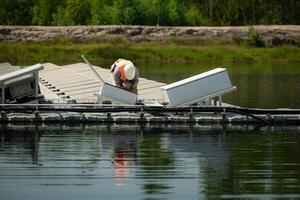 técnico actualmente evaluando y reparando el transmisión terminales para electricidad generado por solar energía en un flotante solar poder sistema. foto