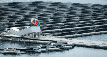 técnico actualmente evaluando y reparando el transmisión terminales para electricidad generado por solar energía en un flotante solar poder sistema. foto