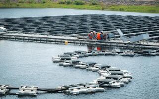 ambos de técnicos son actualmente evaluando y reparando el transmisión terminales para electricidad generado por solar energía en un flotante solar poder sistema. foto