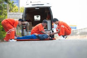 The paramedic  is assisting an injured man in an emergency situation on the road. photo