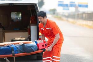 el paramédico es ayudando un lesionado hombre en un emergencia situación en el la carretera. foto