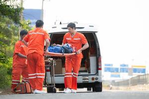 el paramédico es ayudando un lesionado hombre en un emergencia situación en el la carretera. foto