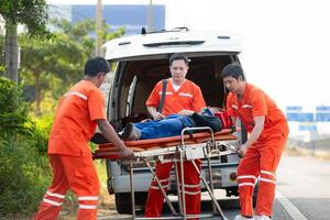 el paramédico es ayudando un lesionado hombre en un emergencia situación en el la carretera. foto