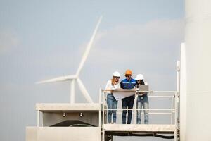 A group of engineers and architects work in floor of base ground of a wind turbine photo