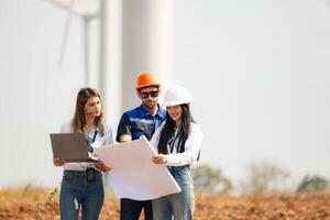 Engineer and Architect working on construction site with wind turbine background. photo