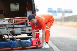 el paramédico es ayudando un lesionado hombre en un emergencia situación en el la carretera. foto