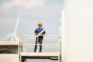 Technician checking wind turbine in wind turbine farm for maintenance. photo