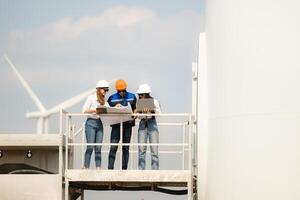 A group of engineers and architects work in floor of base ground of a wind turbine photo