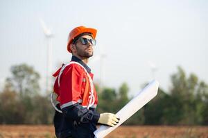 Technician checking wind turbine in wind turbine farm for maintenance. photo