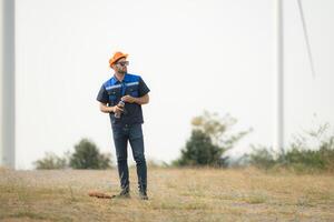 ingeniero trabajando en viento turbina granja con azul cielo antecedentes foto