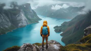 AI generated Traveller standing on top of cliff in cloudy day enjoying beautiful panorama view of blue lake and mountains. photo