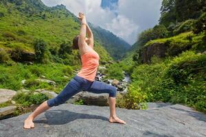 mujer haciendo Ashtanga vinyasa yoga asana virabhadrasana 1 guerrero foto