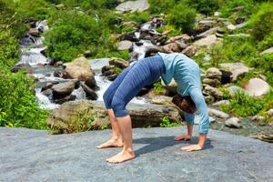 mujer haciendo Ashtanga vinyasa yoga asana urdhva dhanurasana arriba foto