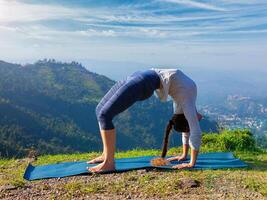 Woman doing Ashtanga Vinyasa Yoga asana Urdhva Dhanurasana outdoors photo