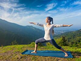 mujer haciendo yoga asana virabhadrasana 2 guerrero actitud al aire libre foto