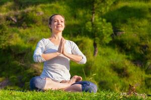 joven deportivo ajuste mujer haciendo yoga loto actitud exteriores foto