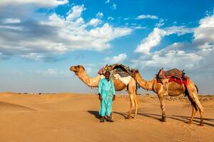 Cameleer camel driver with camels in Rajasthan, India photo