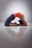 Beautiful sporty fit yogi girl practices yoga asana Kapotasana photo