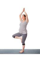 Pregnant woman doing yoga asana Vrikshasana photo